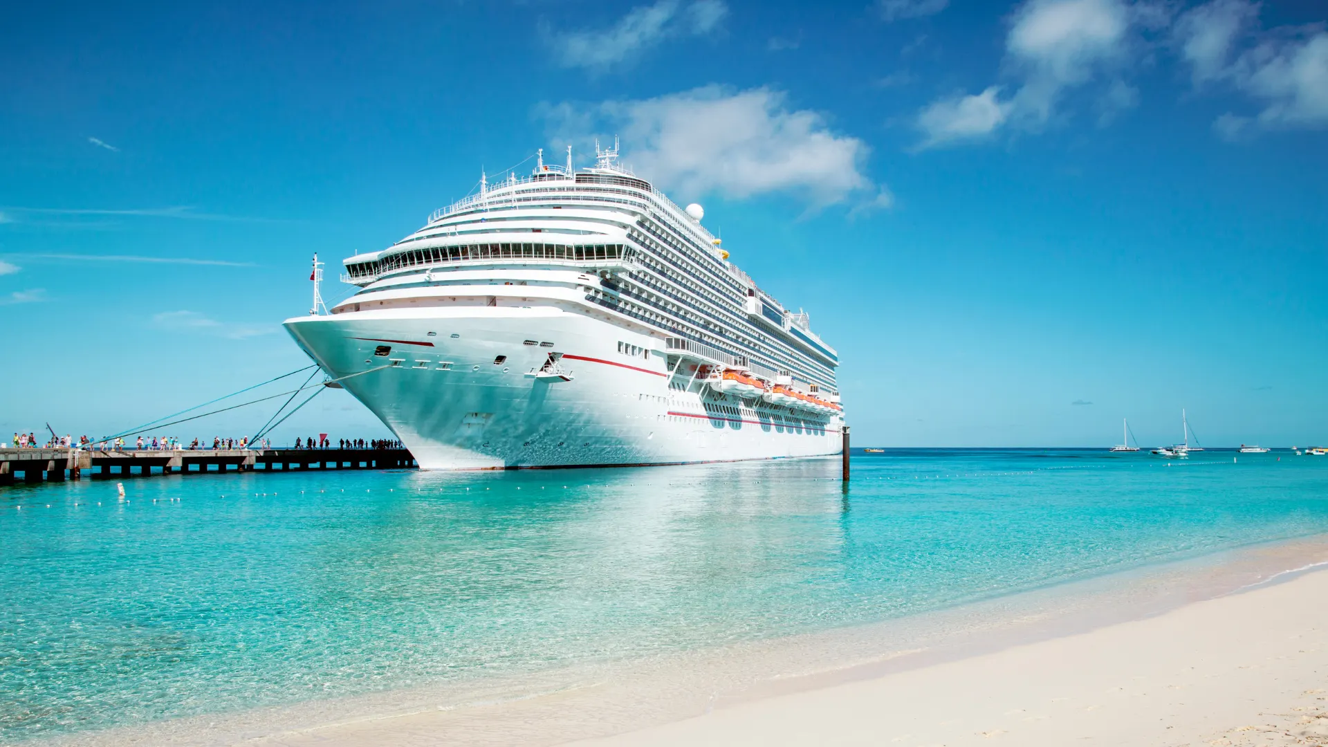 Crucero atracado junto a una playa de aguas turquesa